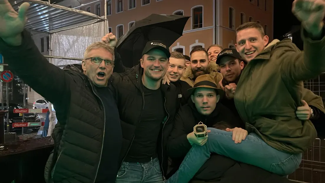 Jubelnde Gruppe mit Stangeplausch-Mützen nachts in Winterthur.